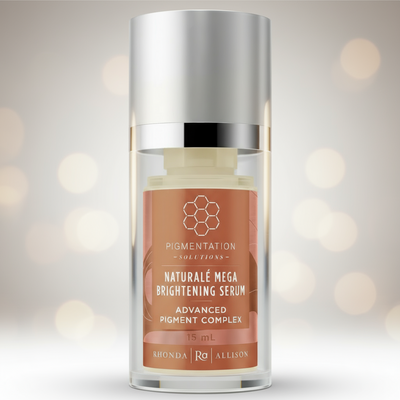 Skincare serum bottle with a silver cap and brown label on a white background